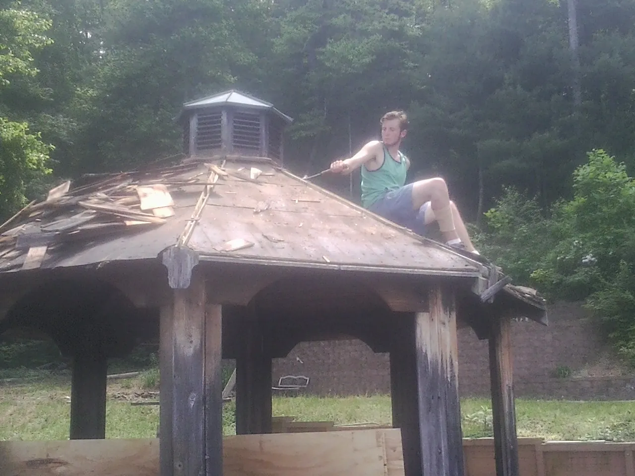 Tearing the old roof off a wooden gazebo before new shakes in Rutherfordton