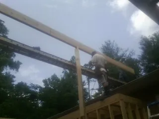 Carpenter setting a ridge beam over a new addition frame — Ice Dam Removal by Roofing Brothers in Rutherfordton
