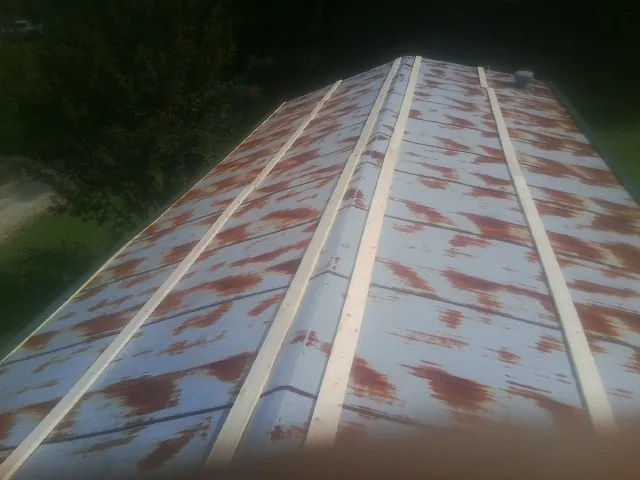 Rusted metal roof panels with new wood purlins before replacement — Storm Damage Roof Repair in Rutherfordton by Roofing Brothers