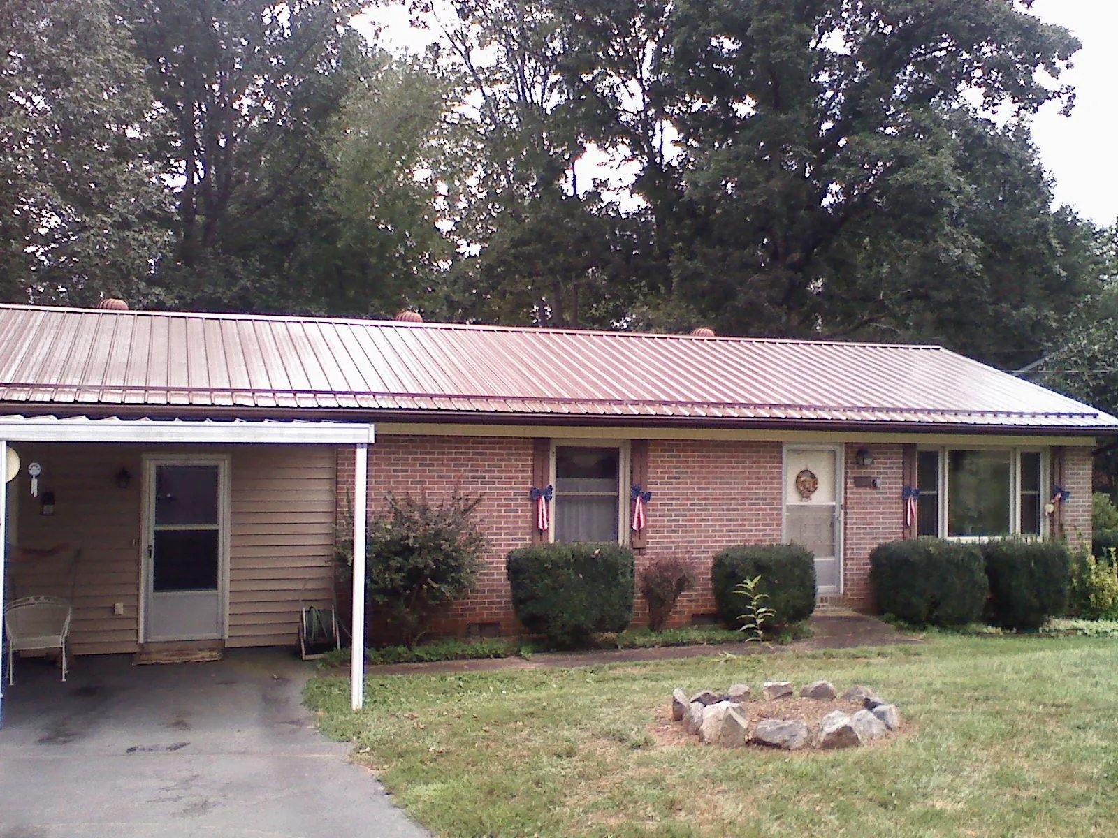 Bronze metal roof and carport on a brick ranch home — Roof Repair work by our crew in Rutherfordton